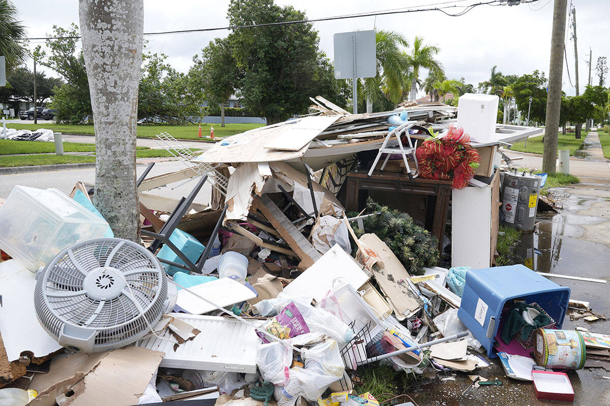 Piles of debris line the sidewalks of Punta Gorda's historic neighborhood damaged by Hurricane ...