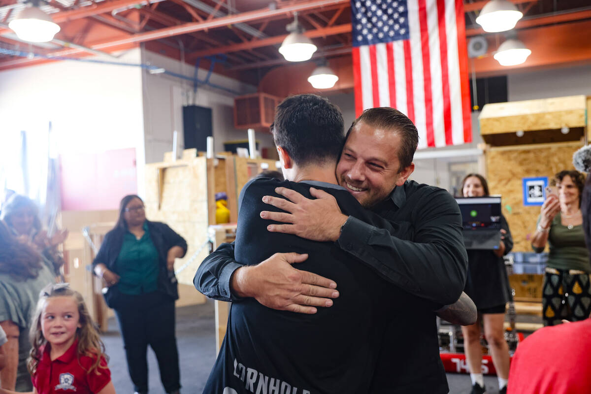 Alex Bechtler, a manufacturing teacher, hugs fellow teacher Patrick Vieira at Southeast Career ...