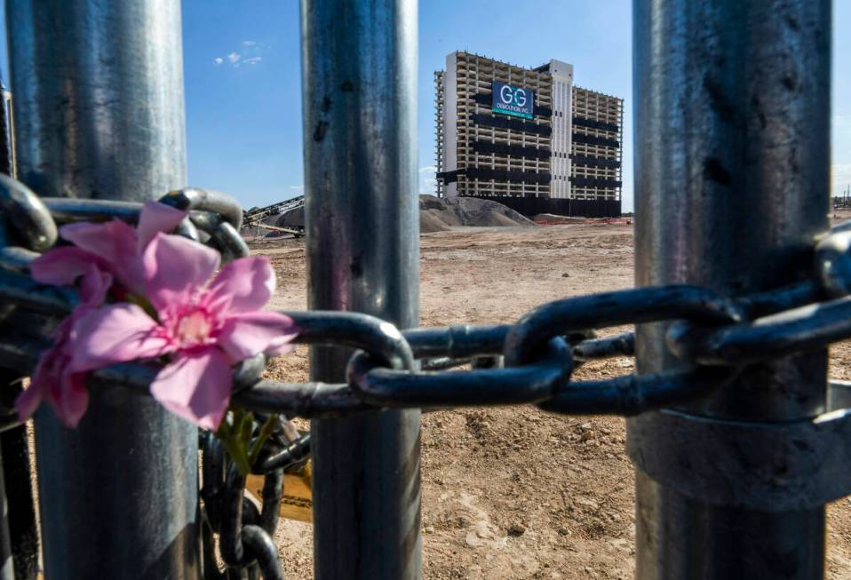 Flowers are left in the chain securing a construction entrance with the Club Tower beyond on th ...