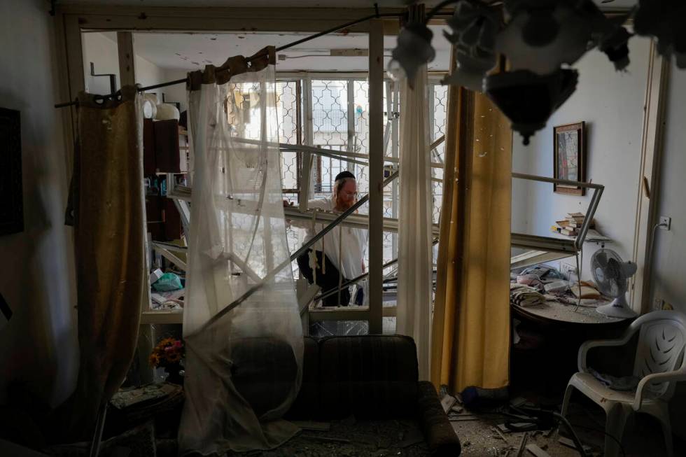 A man examine his damaged apartment that was hit by a rocket fired from Lebanon, in Kiryat Yam, ...