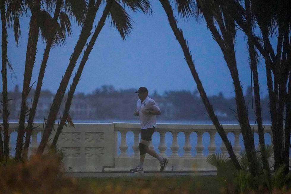 A jogger runs along the bay in heavy rain ahead of Hurricane Milton, Wednesday, Oct. 9, 2024, i ...