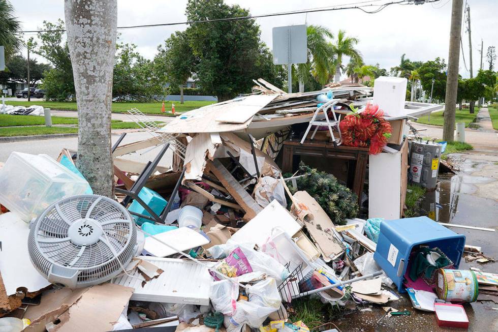 Montones de escombros se alinean en las aceras del barrio histórico de Punta Gorda dañado por ...