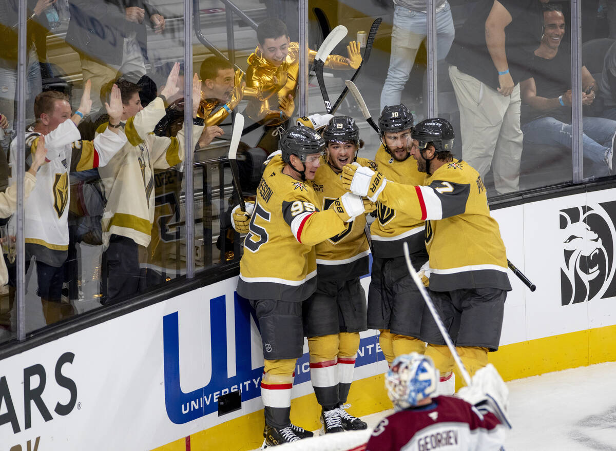 Vegas Golden Knights players and fans celebrate a goal during the NHL hockey game against the C ...