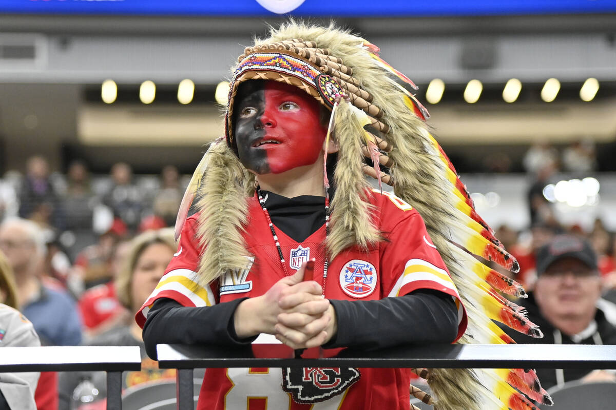 A young Kansas City Chiefs fan, dressed with a headdress and face paint, looks on during an NFL ...