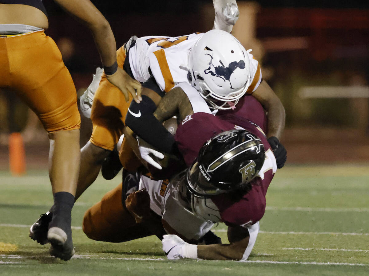 Legacy High's linebacker Martell Mckenzie (22) takes down Faith Lutheran's Cale Breslin (14) du ...