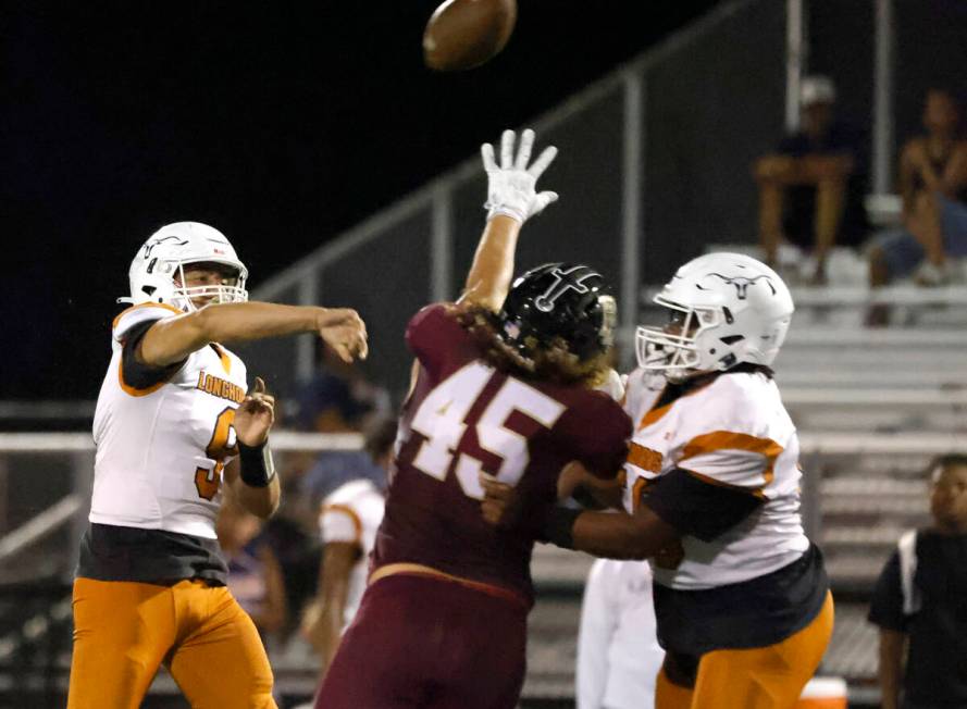 Legacy High's quarterback Aidan Crawford (9) throws under pressure from Faith Lutheran High's M ...