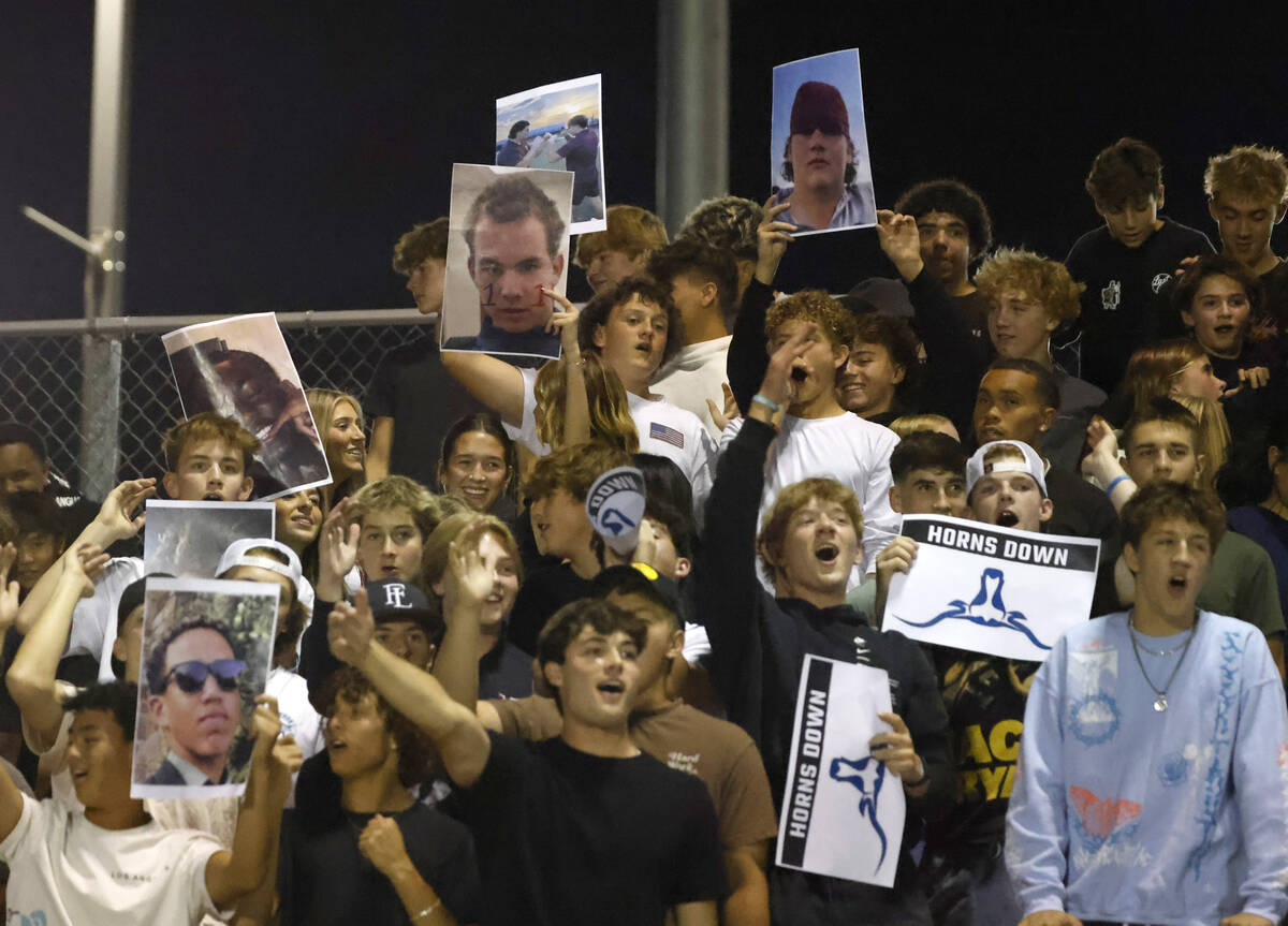 Faith Lutheran High's fans display players photographs as they cheer for their team during the ...