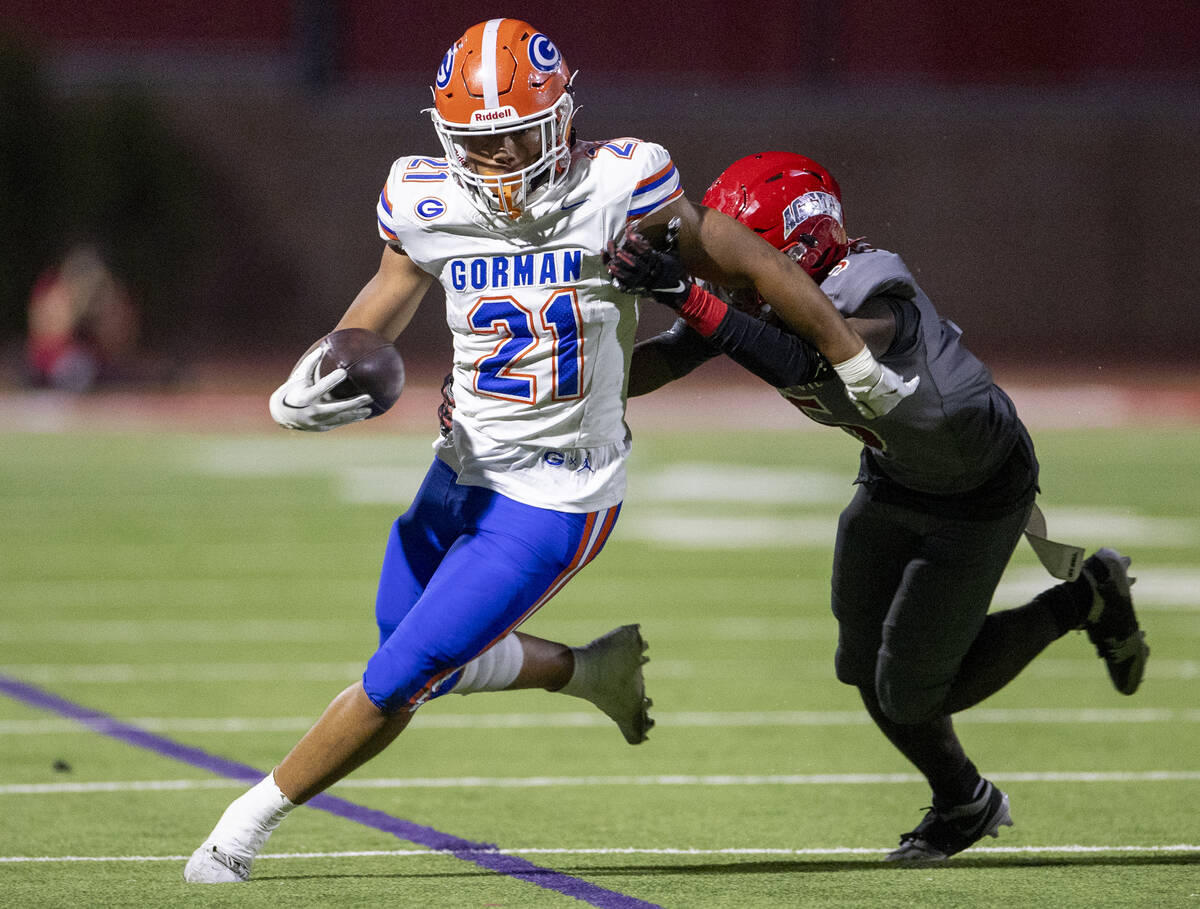 Bishop Gorman running back Jonathan Coar (21) avoids a tackle during the high school football g ...