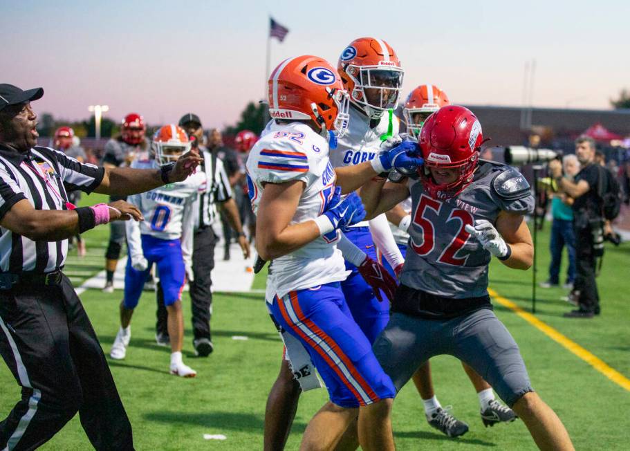 Bishop Gorman linebacker Brodey Correa (52) holds on to the helmet of Arbor View linebacker Roc ...