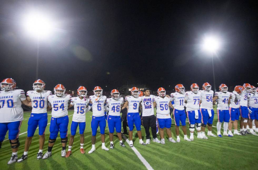 Bishop Gorman players interlock arms after defeating Arbor View 49-14 in the high school footba ...