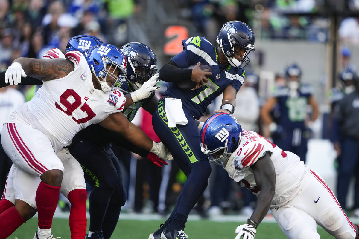 Seattle Seahawks quarterback Geno Smith (7) is tackled by New York Giants defensive tackle Dext ...