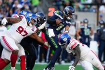 Seattle Seahawks quarterback Geno Smith (7) is tackled by New York Giants defensive tackle Dext ...