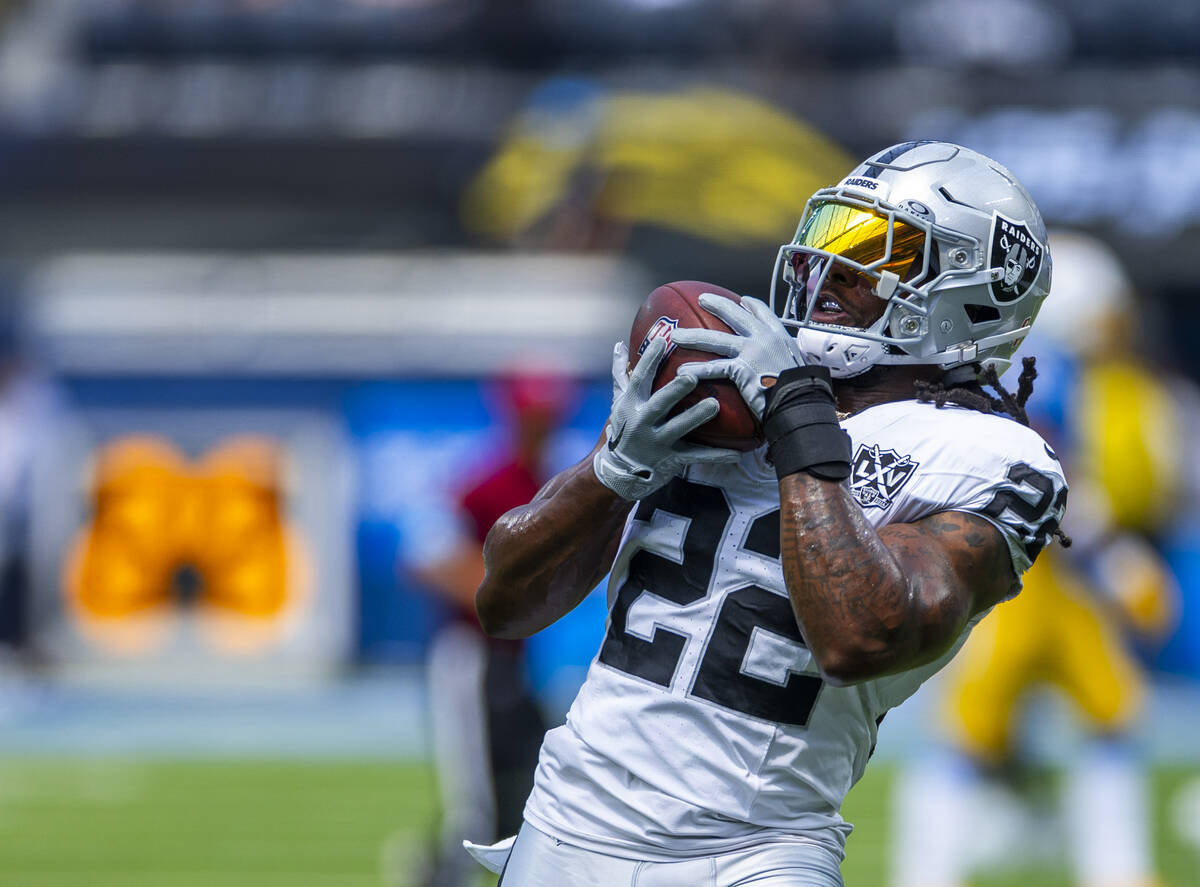 Raiders running back Alexander Mattison (22) catches a pass as they warm up to face the Los Ang ...