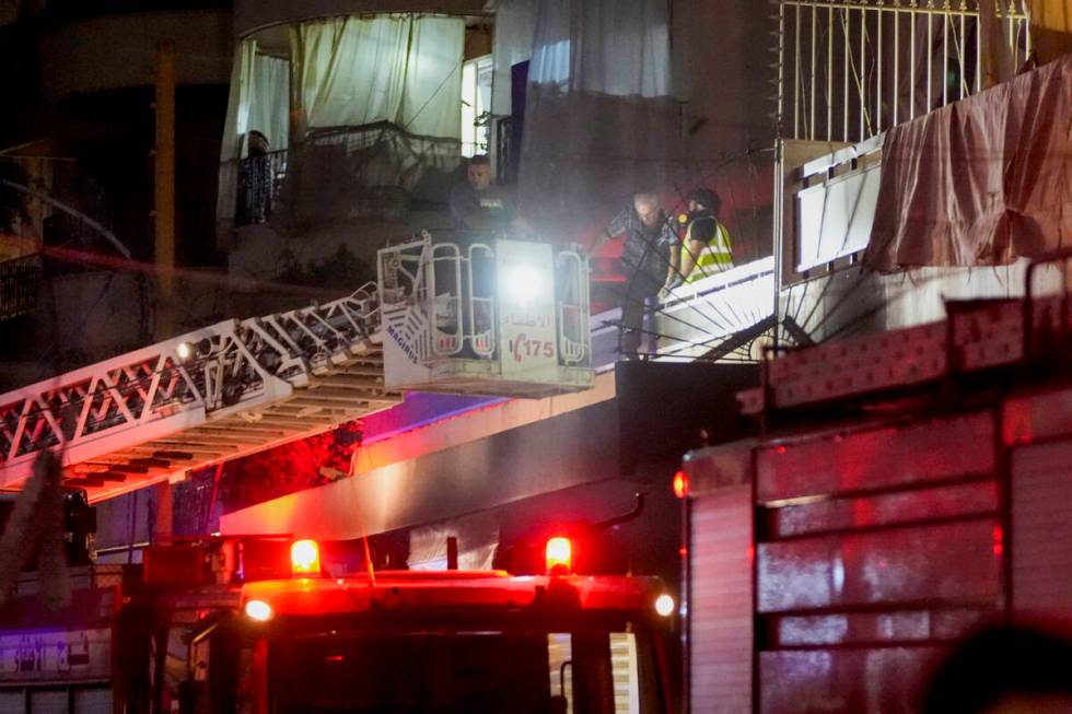 Emergency workers rescue an elderly man from a damaged building hit by an Israeli airstrike at ...