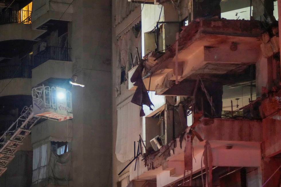 A rescue worker searches for survivors inside a damaged building hit by an Israeli airstrike in ...