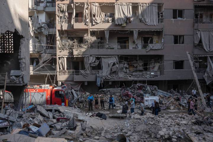 Rescue workers and members of the media work at the site of an Israeli airstrike on apartment b ...