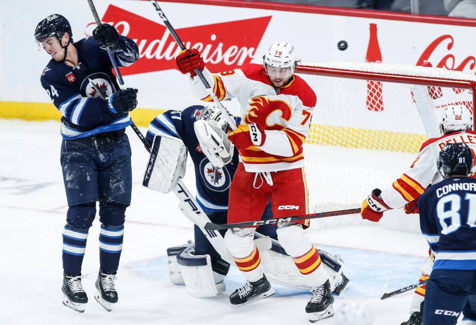 Calgary Flames' Cole Schwindt (79) tips the puck wide of Winnipeg Jets goaltender Connor Helleb ...