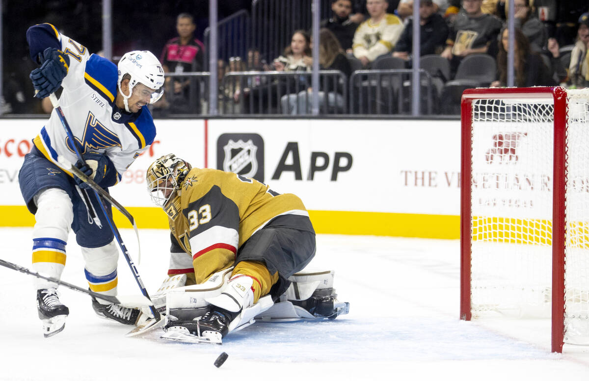 Golden Knights goaltender Adin Hill (33) blocks a shot from St. Louis Blues right wing Mathieu ...