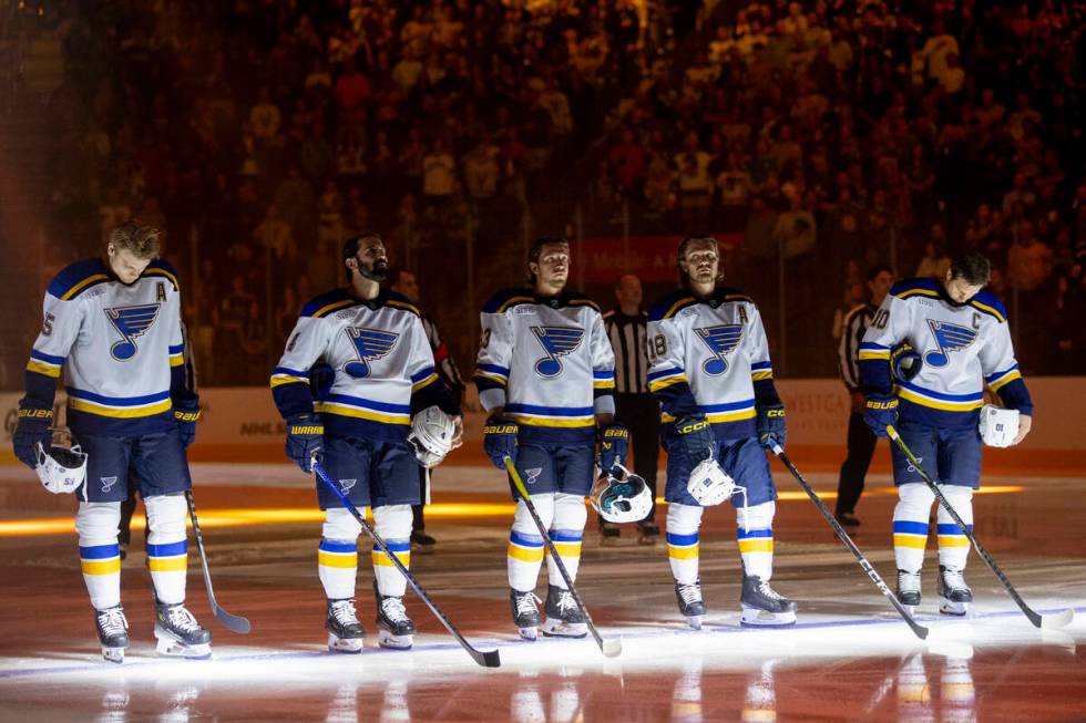 The St. Louis Blues starting lineup stands on the ice for the national anthem during the NHL ho ...