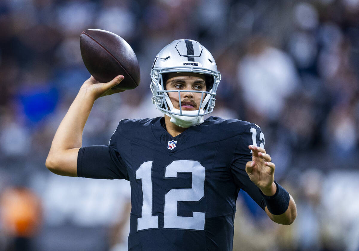 Raiders quarterback Aidan O'Connell (12) looks to pass as they face the Dallas Cowboys for thei ...