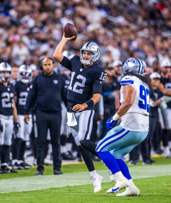 Raiders quarterback Aidan O'Connell (12) gets off a pass over Dallas Cowboys defensive end Vili ...