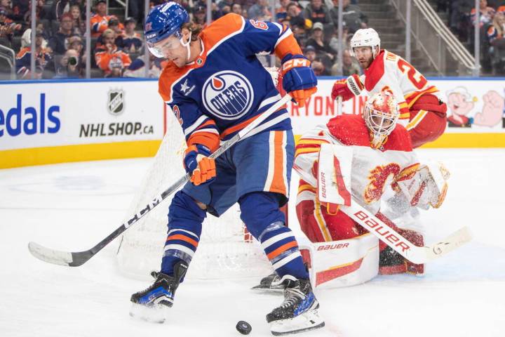 Calgary Flames goalie Devin Cooley, center, and Jarred Tinordi (26) watch as Edmonton Oilers' R ...