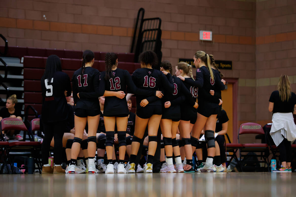 Faith Lutheran huddles up after the first set during a volleyball game between Faith Lutheran a ...