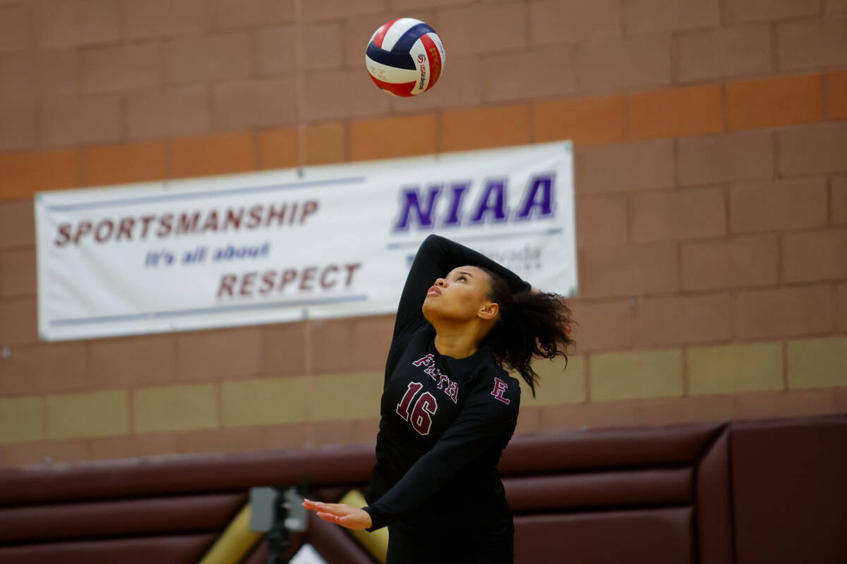 Faith Lutheran middle blocker Andrea Romero-Agosto (16) serves the ball during a volleyball gam ...