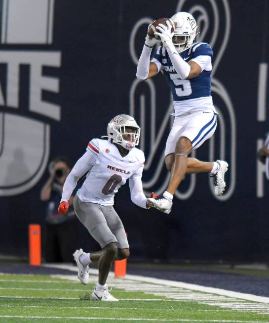 Utah State wide receiver Otto Tia (5) catches a pass as UNLV defensive back Tony Grimes (0) def ...