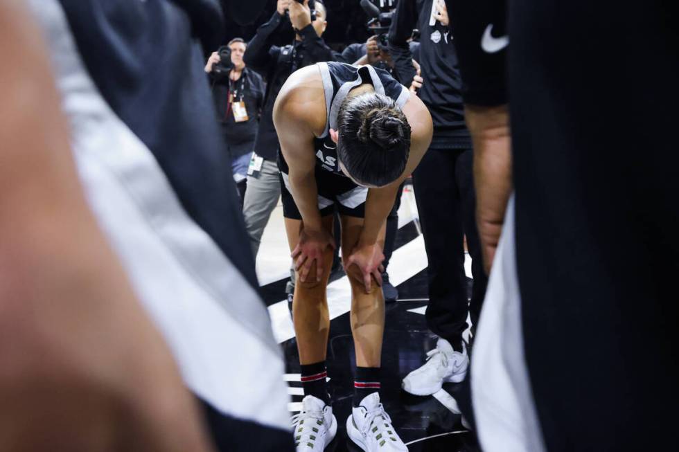 Aces guard Kelsey Plum keeps her head down in the team huddle following a 76-62 loss during gam ...