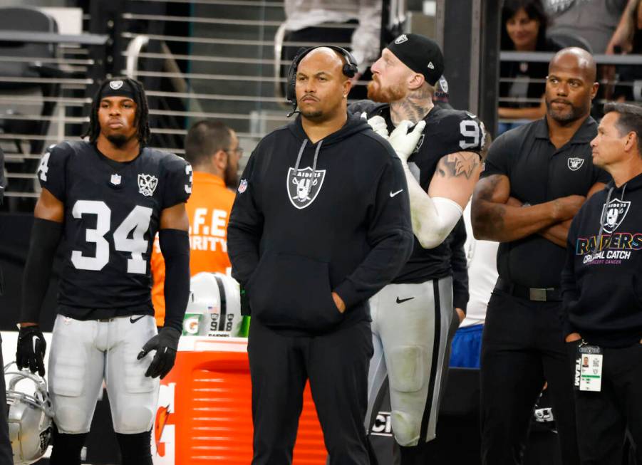 Raiders head coach Antonio Pierce and defensive end Maxx Crosby (98) safety Thomas Harper (34) ...