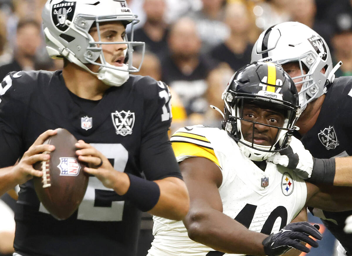 Raiders quarterback Aidan O'Connell (12) throws under pressure from Pittsburgh Steelers linebac ...