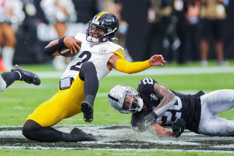 Pittsburgh Steelers quarterback Justin Fields (2) falls onto the Raiders logo after being grabb ...