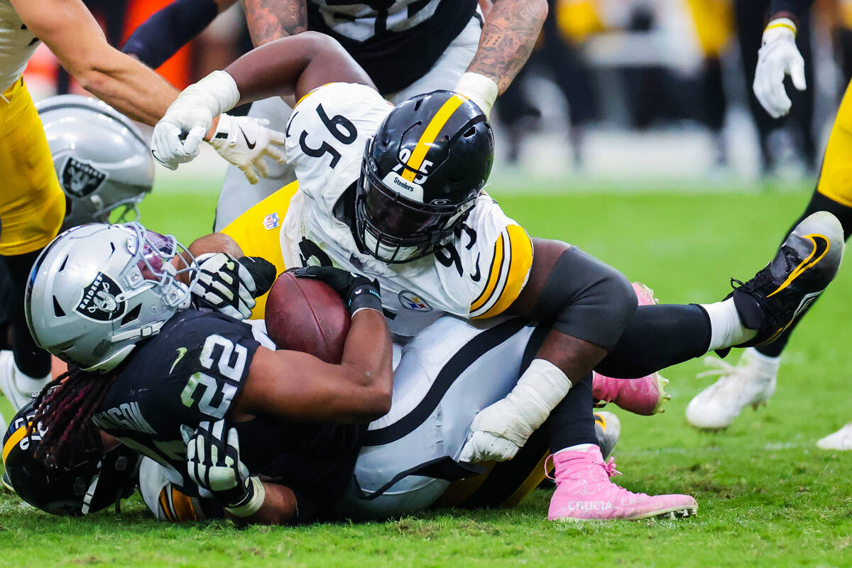 Raiders running back Alexander Mattison (22) is toppled by Pittsburgh Steelers defensive tackle ...