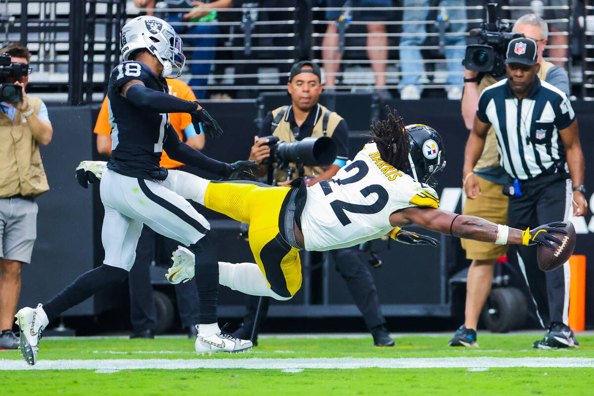 Pittsburgh Steelers running back Najee Harris (22) reaches his arm out as he falls with the bal ...