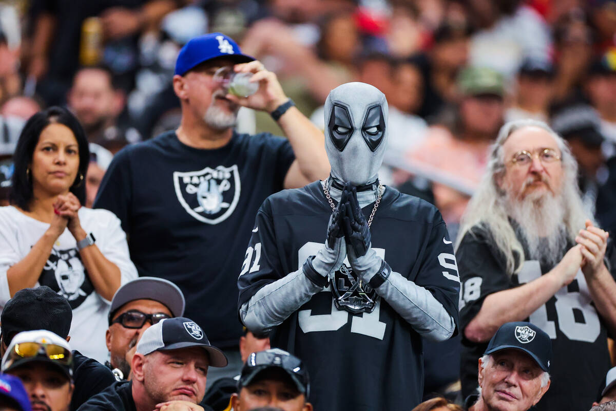 A Raiders fan dressed as Deadpool watches game action during the second half of an NFL football ...