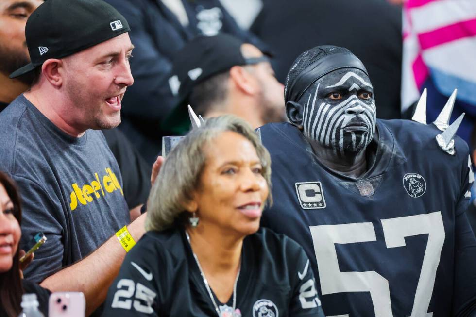 A Pittsburgh Steelers fan tries to talk to a Raiders fan during the second half off an NFL foot ...