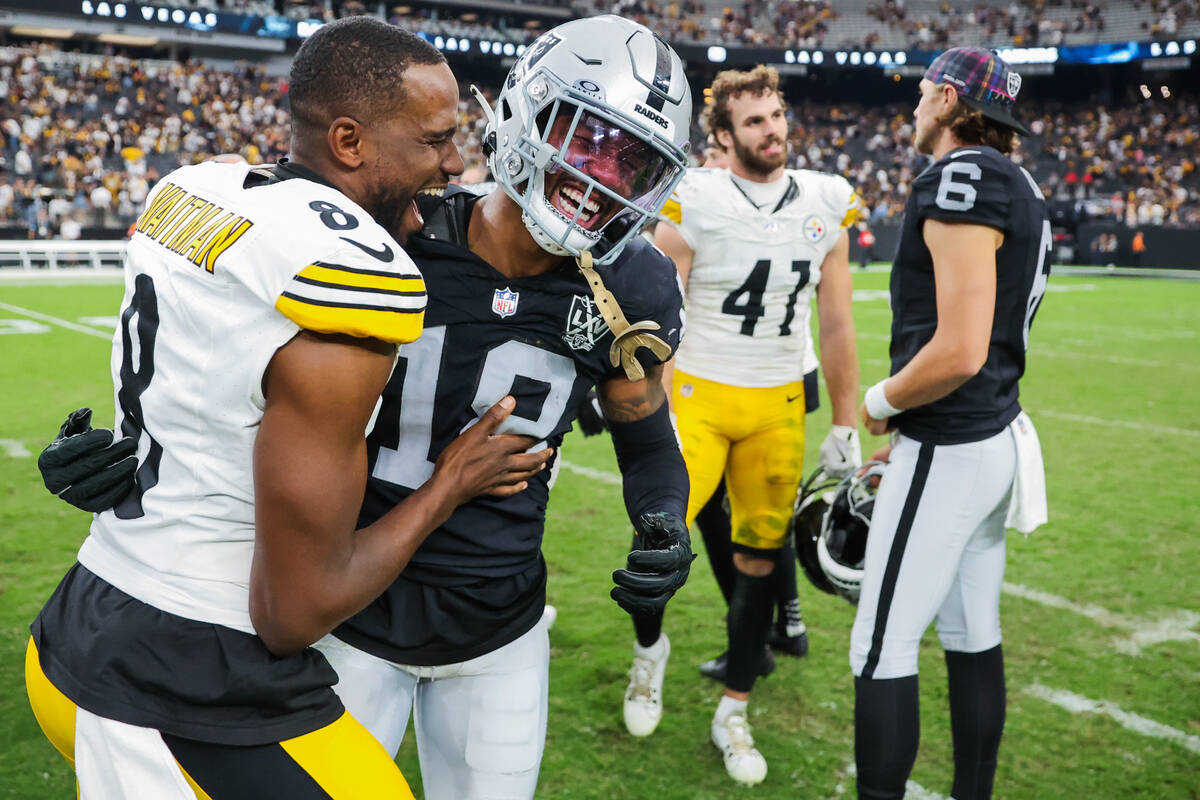 Raiders cornerback Jack Jones (18) shares a laugh with Pittsburgh Steelers punter Corliss Waitm ...