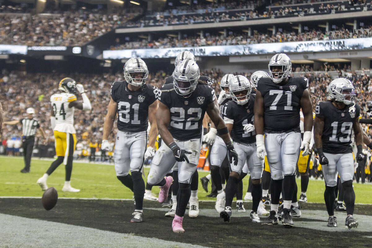 Raiders running back Alexander Mattison (22) celebrates his touchdown with wide receiver Alex B ...