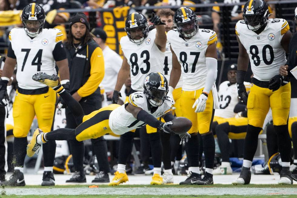 Pittsburgh Steelers wide receiver George Pickens (14) lays out to extend himself in an attempt ...