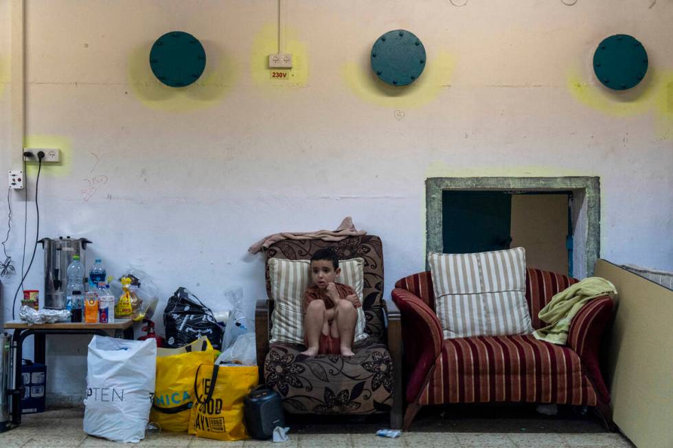 A boy sits in a public bomb shelter to be safe from rockets fired from Lebanon in Acre, norther ...