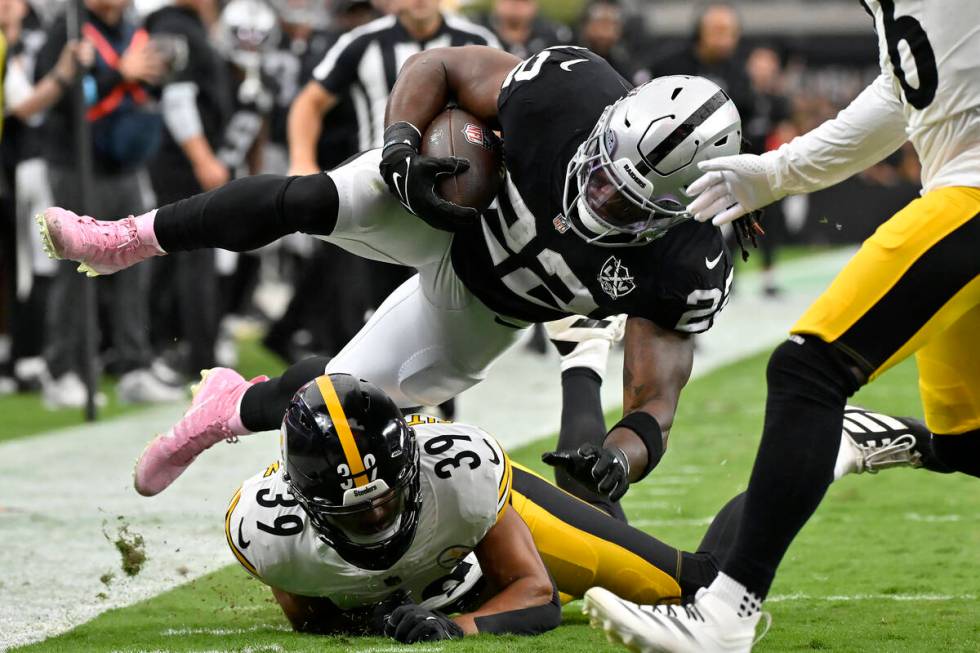 Las Vegas Raiders running back Alexander Mattison (22) is tackled by Pittsburgh Steelers safety ...