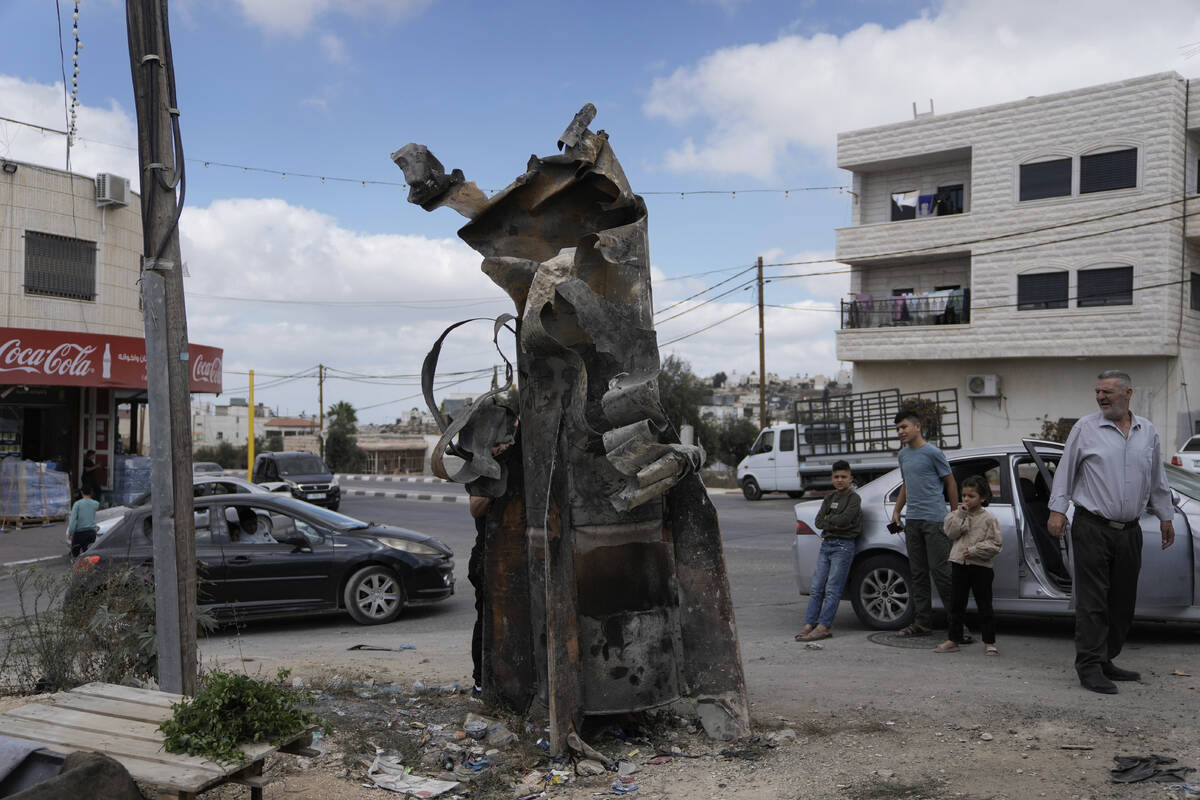 FILE - Palestinians inspect the debris of an Iranian missile intercepted by Israel, in the West ...