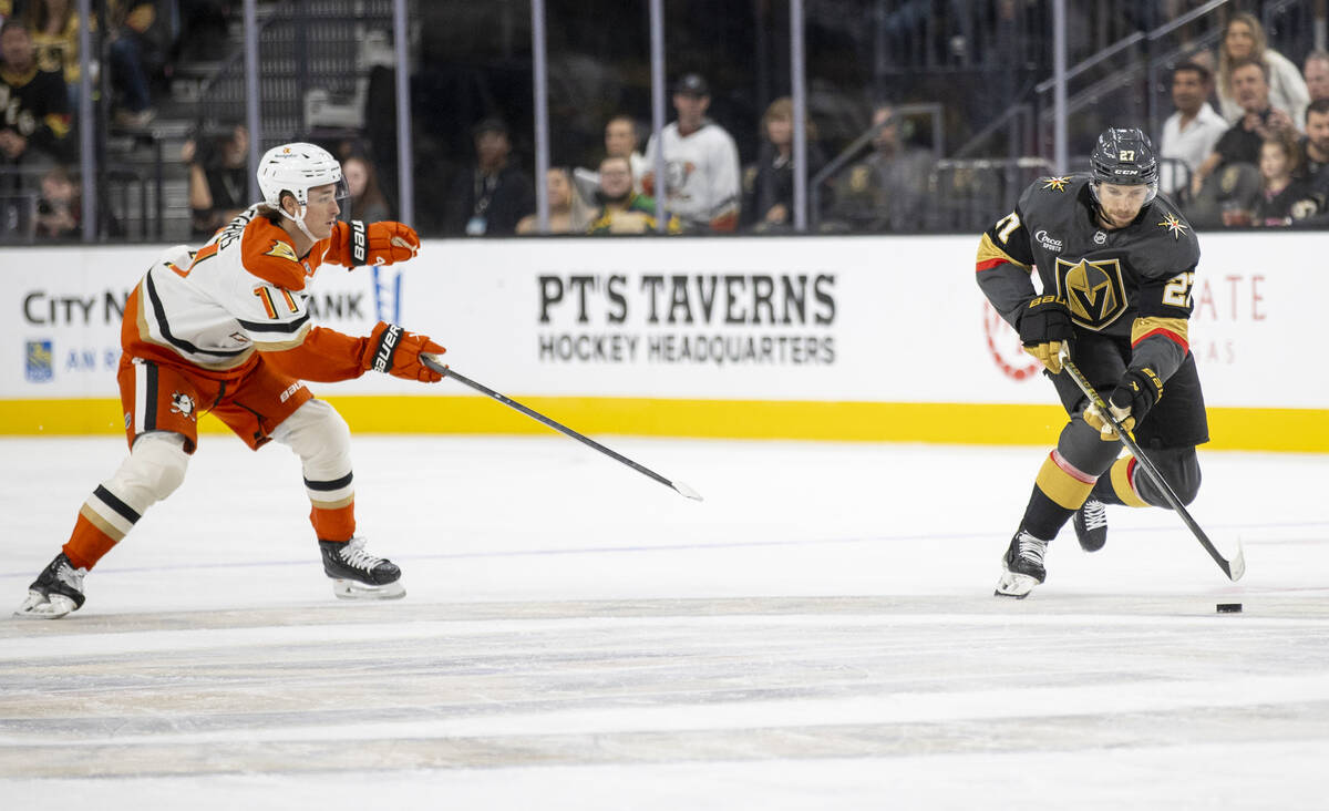 Golden Knights defenseman Shea Theodore (27) keeps the puck from Anaheim Ducks center Trevor Ze ...