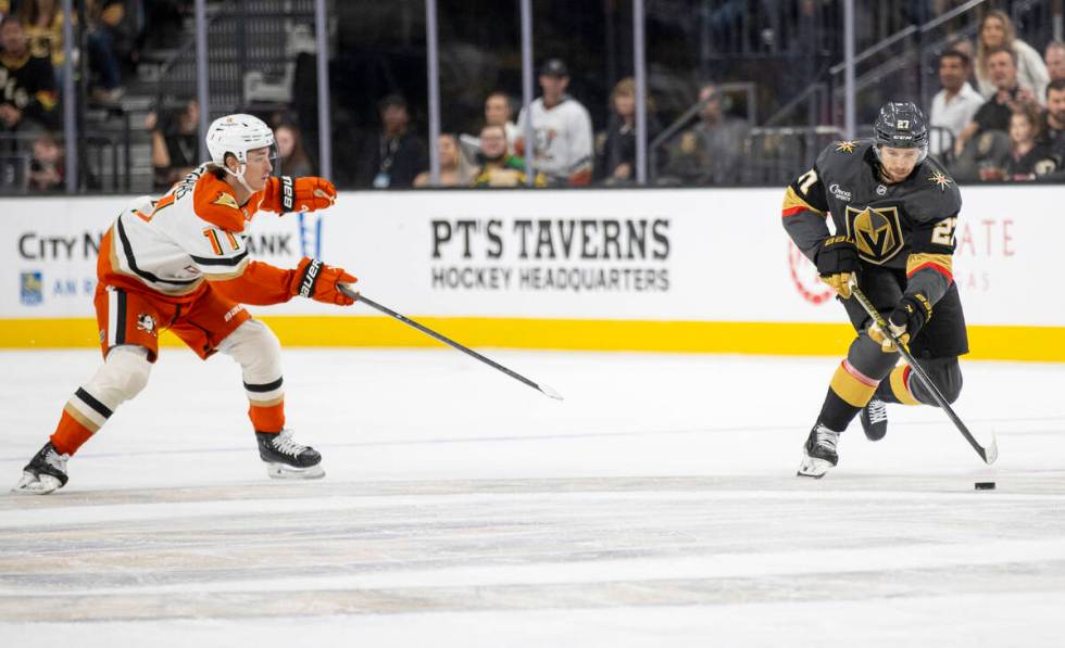 Golden Knights defenseman Shea Theodore (27) keeps the puck from Anaheim Ducks center Trevor Ze ...