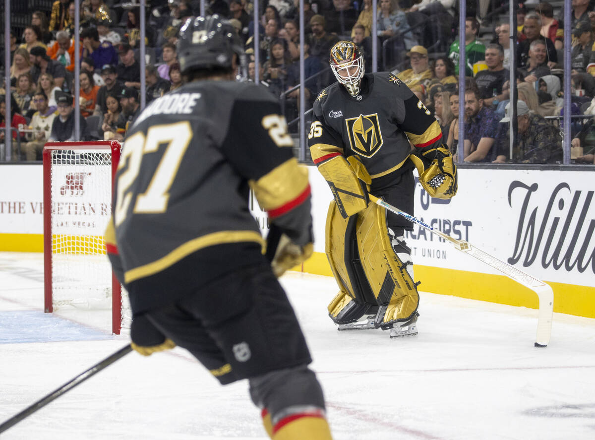 Golden Knights goaltender Ilya Samsonov (35) settles a puck for defenseman Shea Theodore (27) t ...