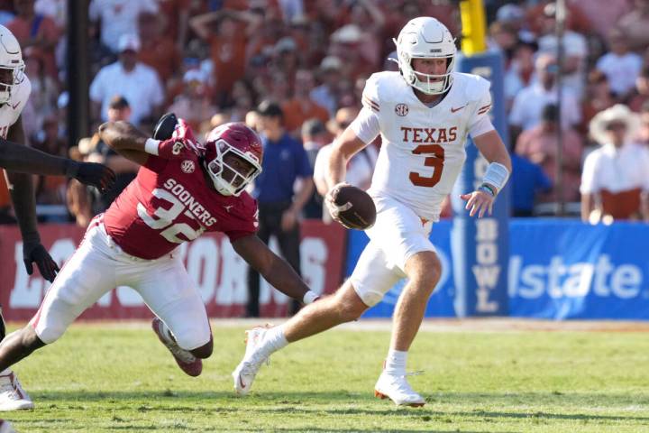 Texas Longhorns quarterback Quinn Ewers (3) runs away from Oklahoma Sooners defensive lineman R ...