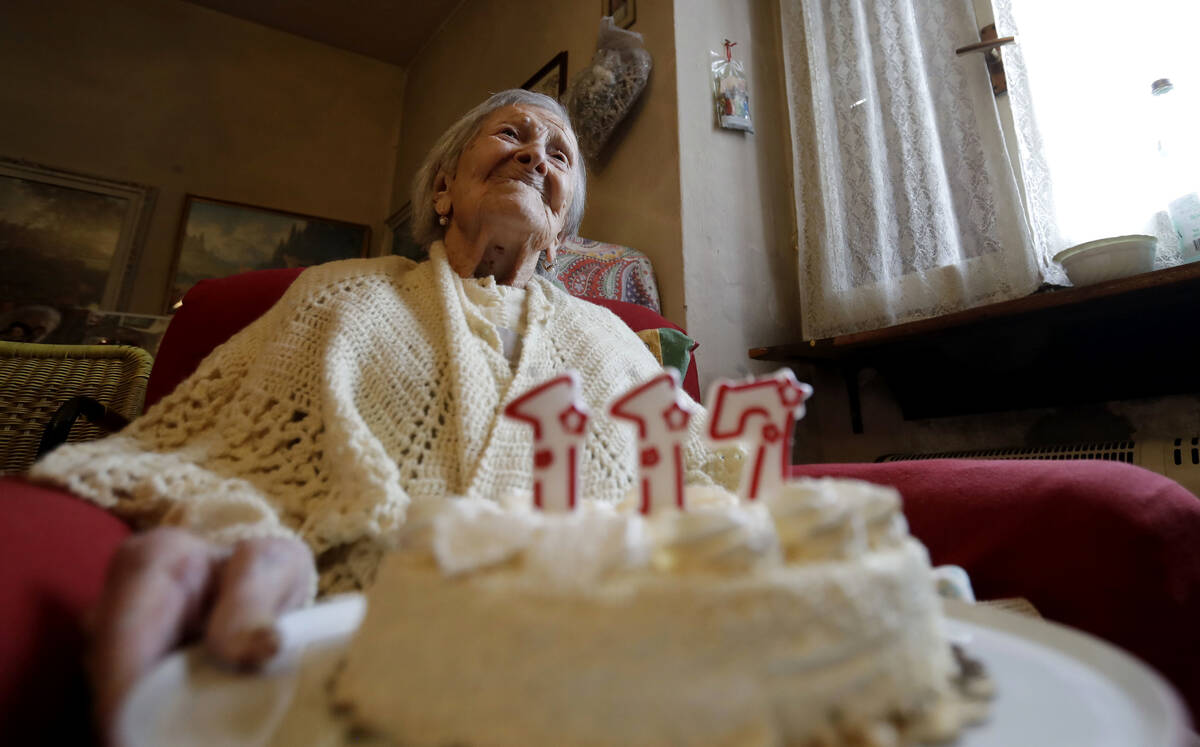 FILE- Emma Morano holds a cake with candles marking 117 years on the day of her birthday, Nov. ...