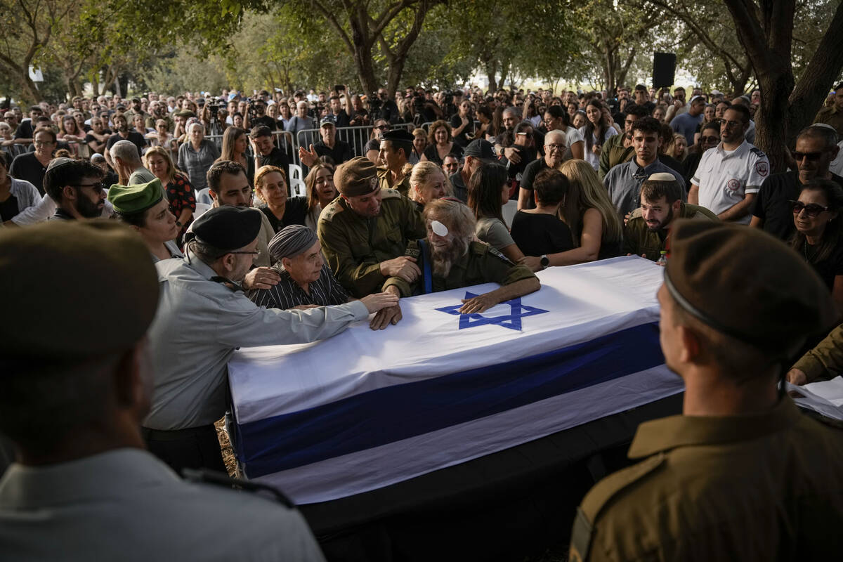 People mourn over the flagged-covered coffin of Israeli soldier Sgt. Amitai Alon, killed by a H ...