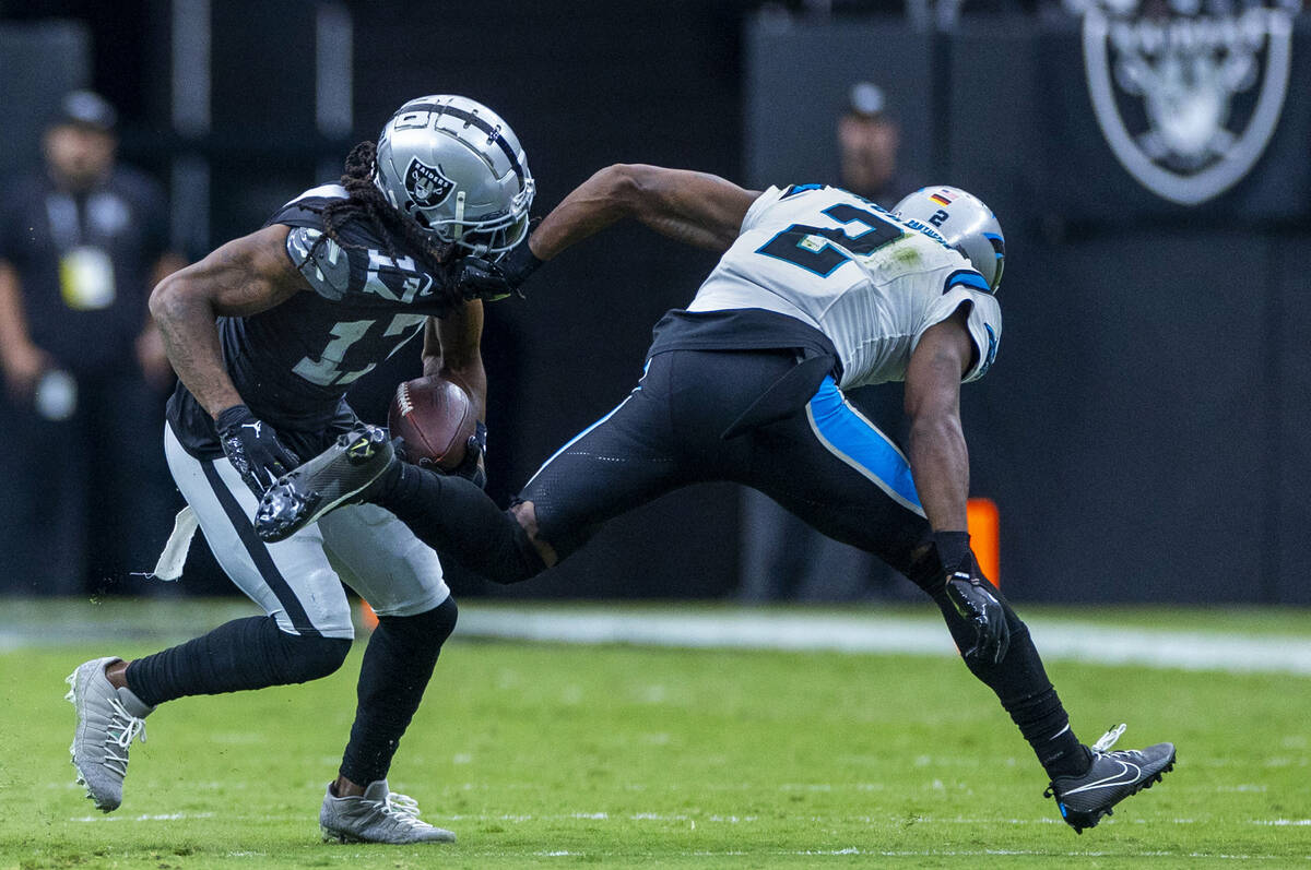 Raiders wide receiver Davante Adams (17) evades a tackle attempt by Carolina Panthers cornerbac ...